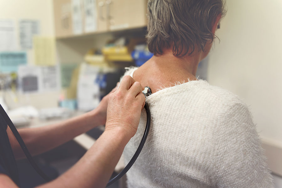 Woman getting lungs listened to with stethoscope